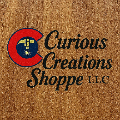 Logo of Curious Creations Shoppe LLC on a wooden background